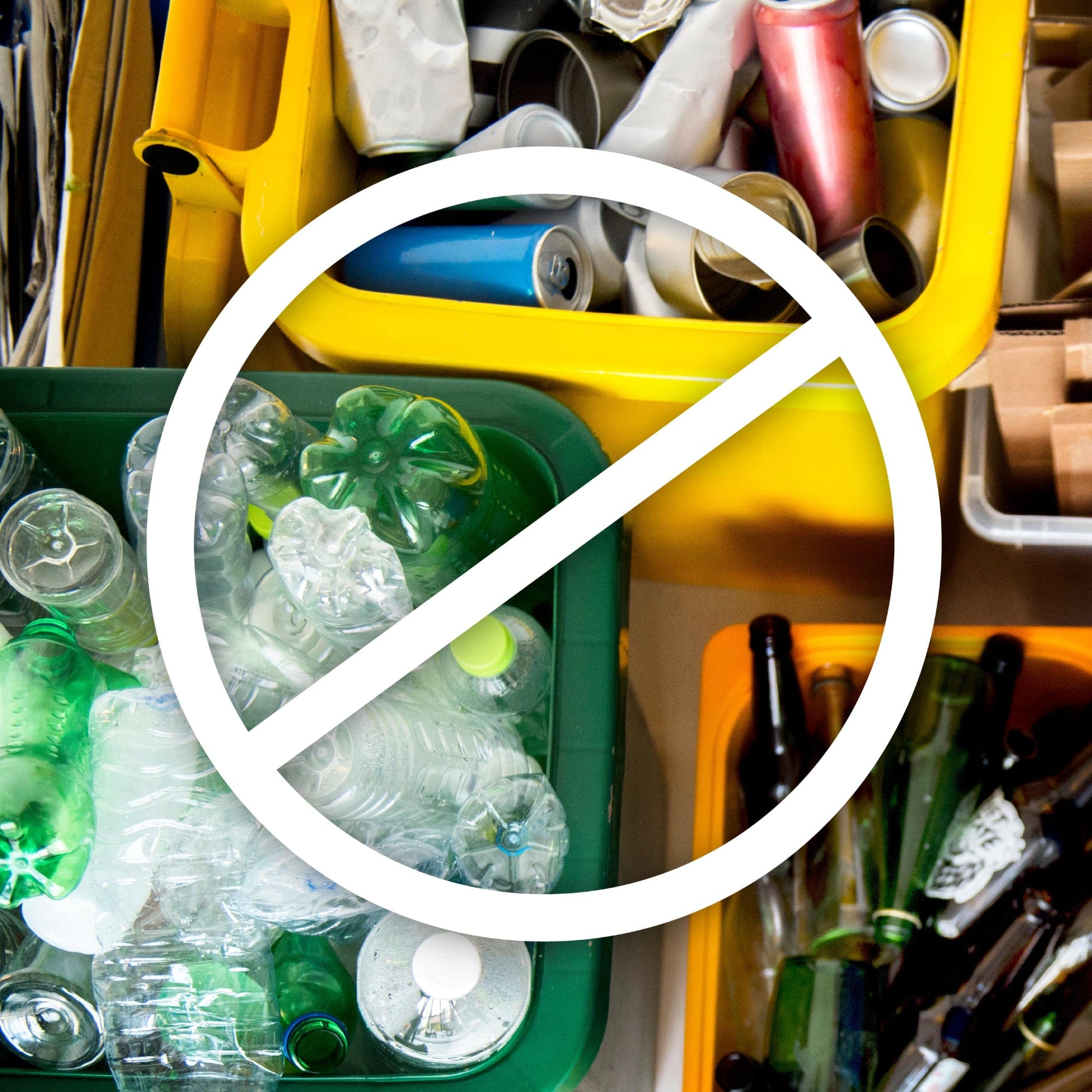 Bins of recycling with bottles and cans, with a large white cross-through sign