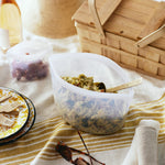 all: clear 8-cup bowl holding pasta salad on a picnic blanket. 
