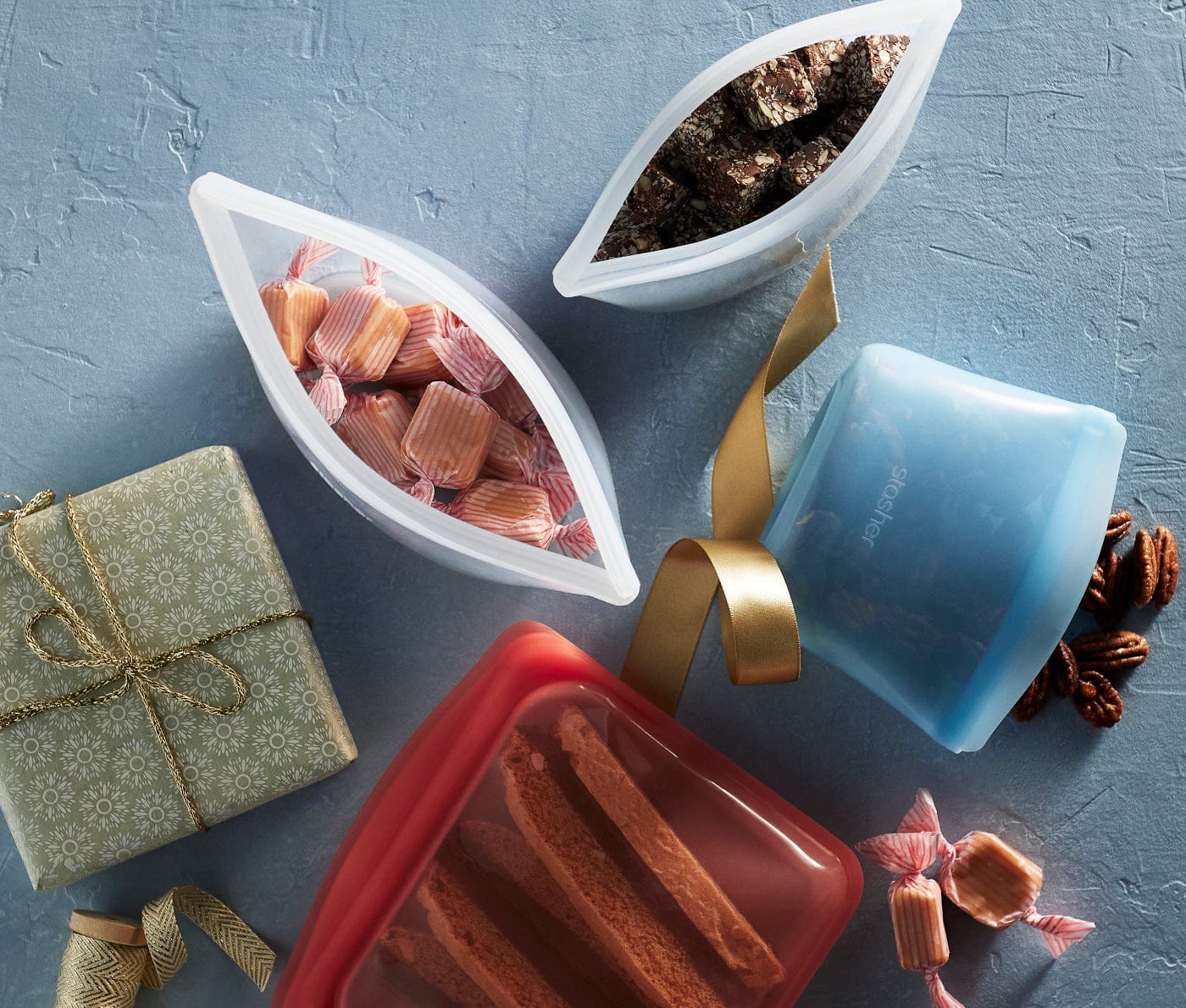 Up to 30% off plus a free half gallon in orders over $80. Image of Stasher bags and bowls holding holiday treats on a blue background. 