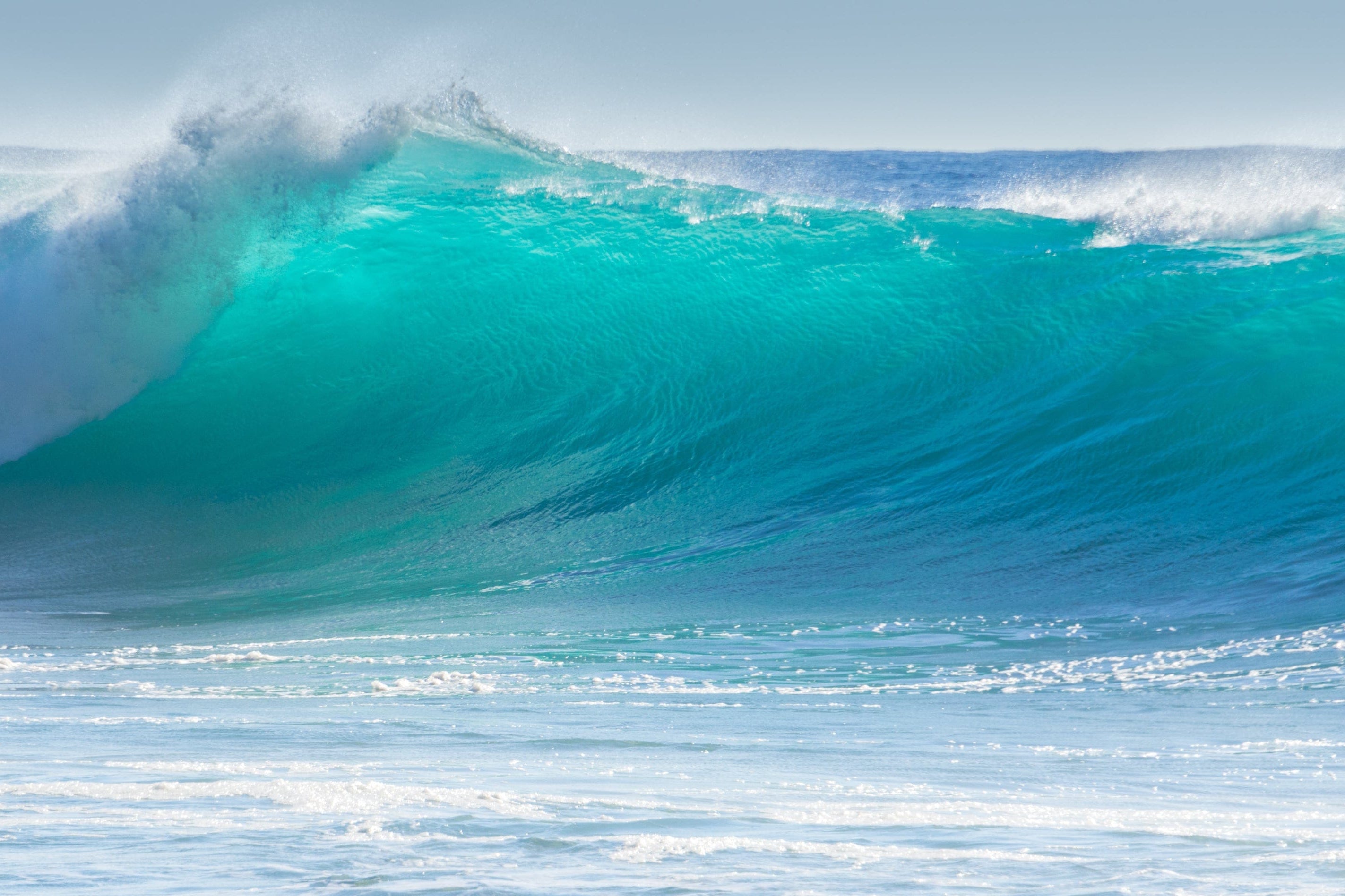 Image of a crashing blue ocean wave.