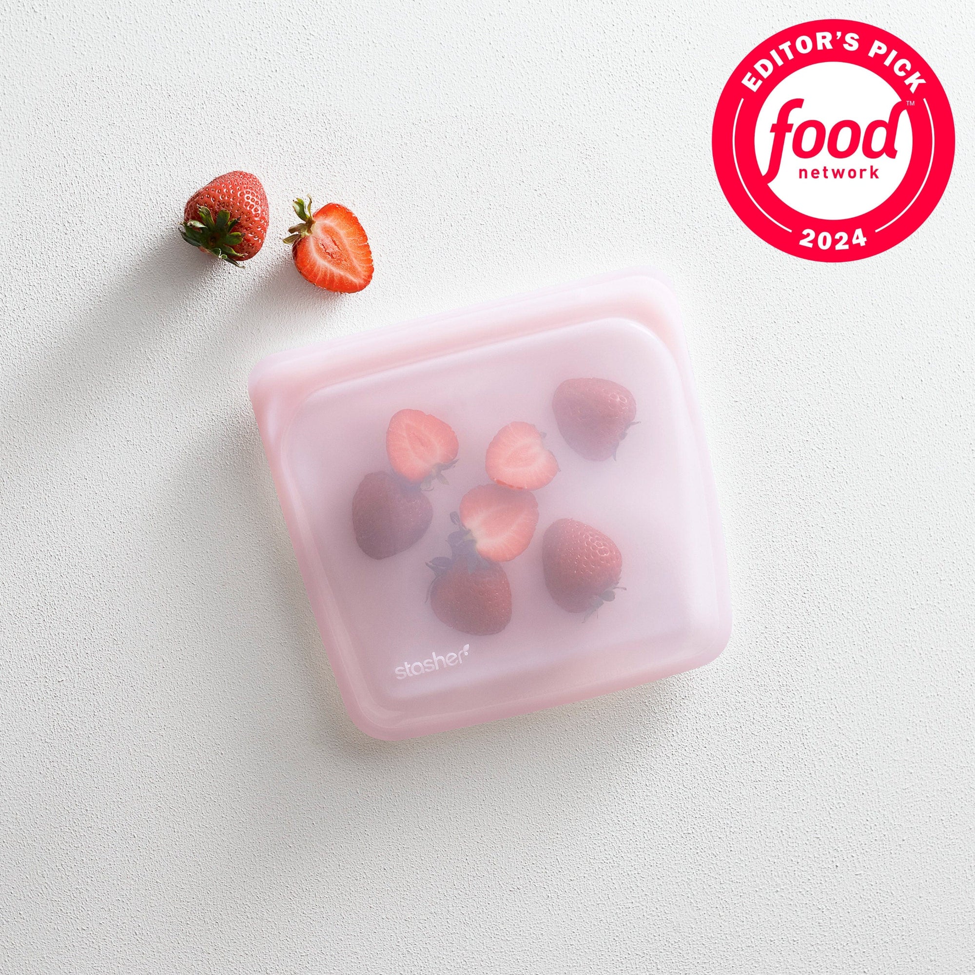 pink: pink sandwich bag holding strawberries