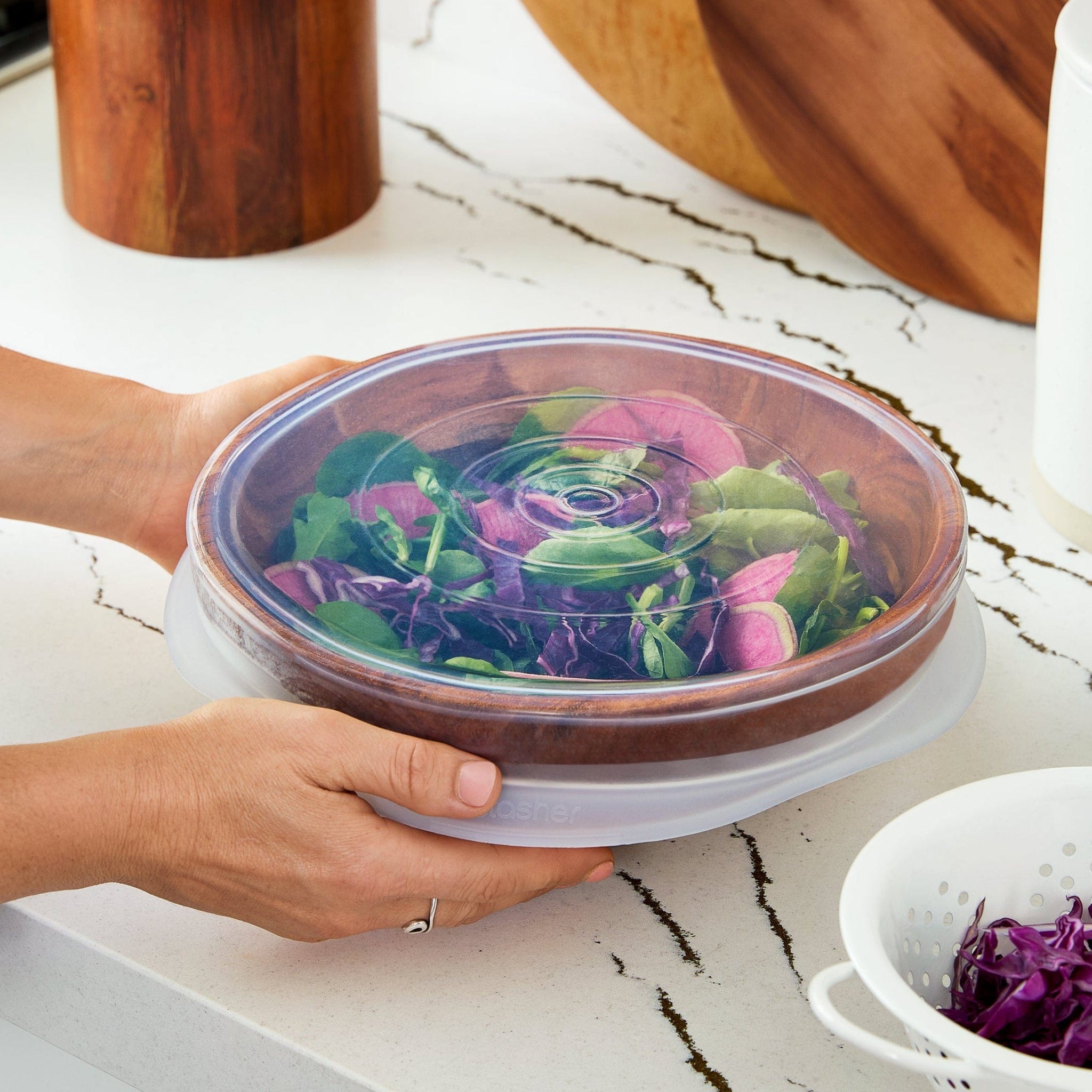all: large stretch lid covering a large wooden bowl filled with salad.