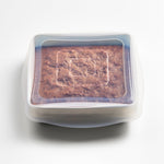 all: Square stretch lid with brownies inside on a white background