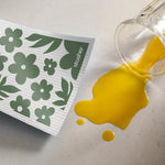 floral moss: stasher reusable swedish dish cloth cleaning up a spilled glass of orange juice