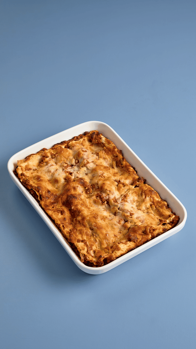 woman stretching a 9x13 rectangle stretch lid over a casserole dish. 