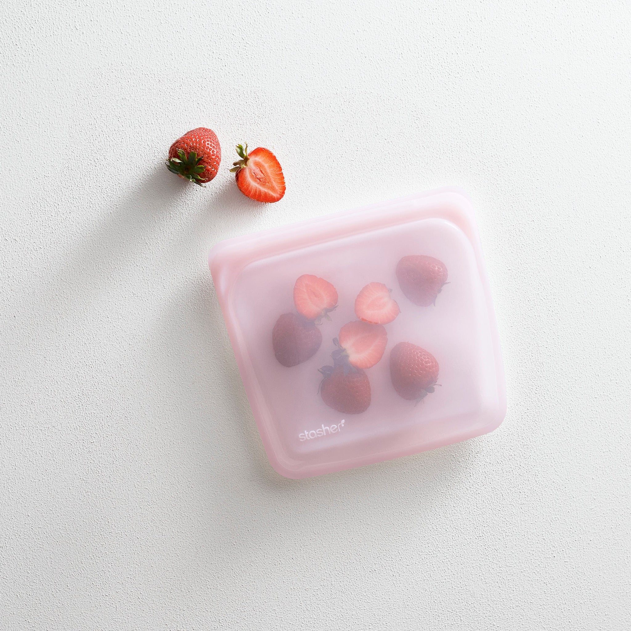 pink: sandwich bag holding strawberries